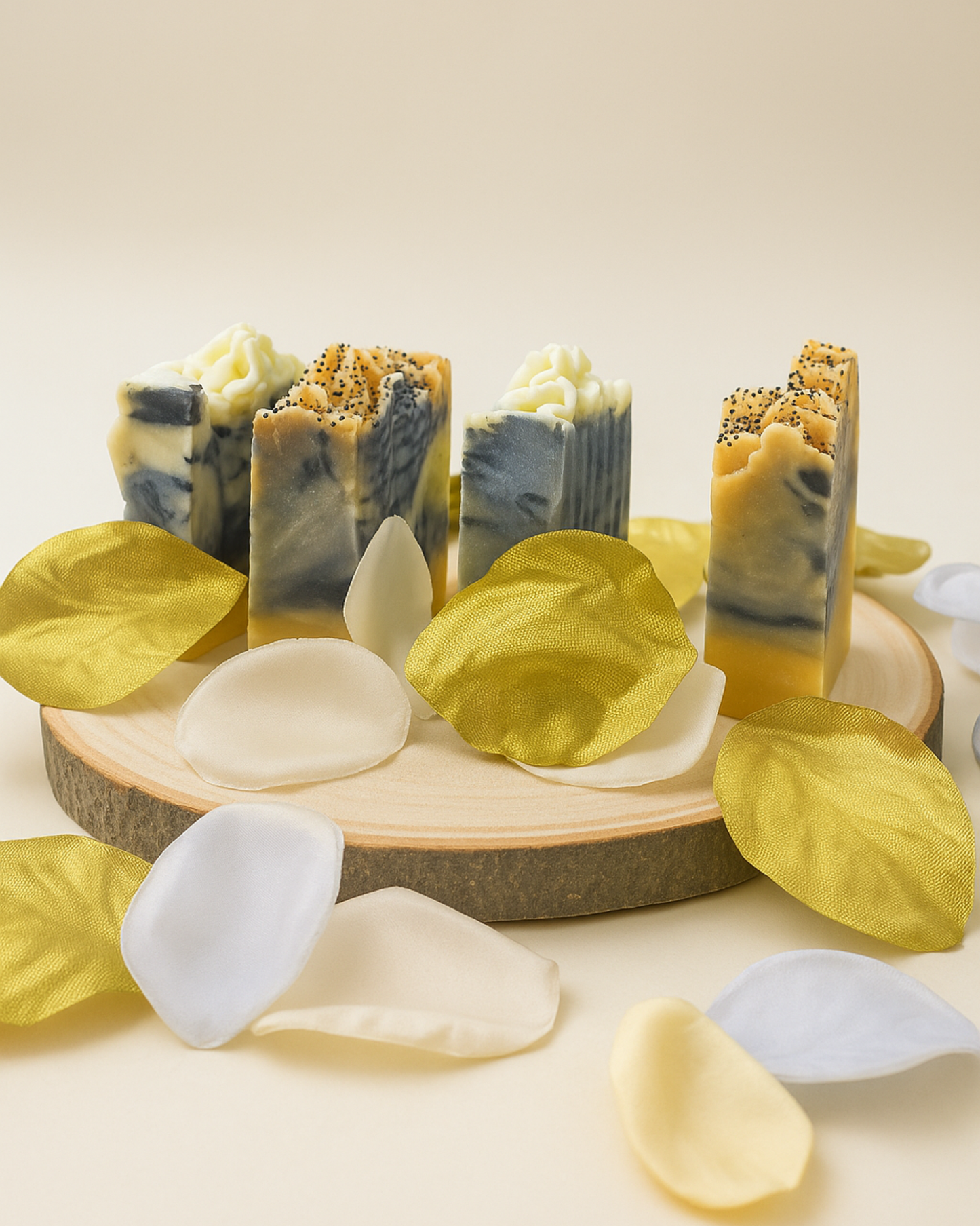 Collection of handmade charcoal soaps on a wooden board with leaves and petals.
