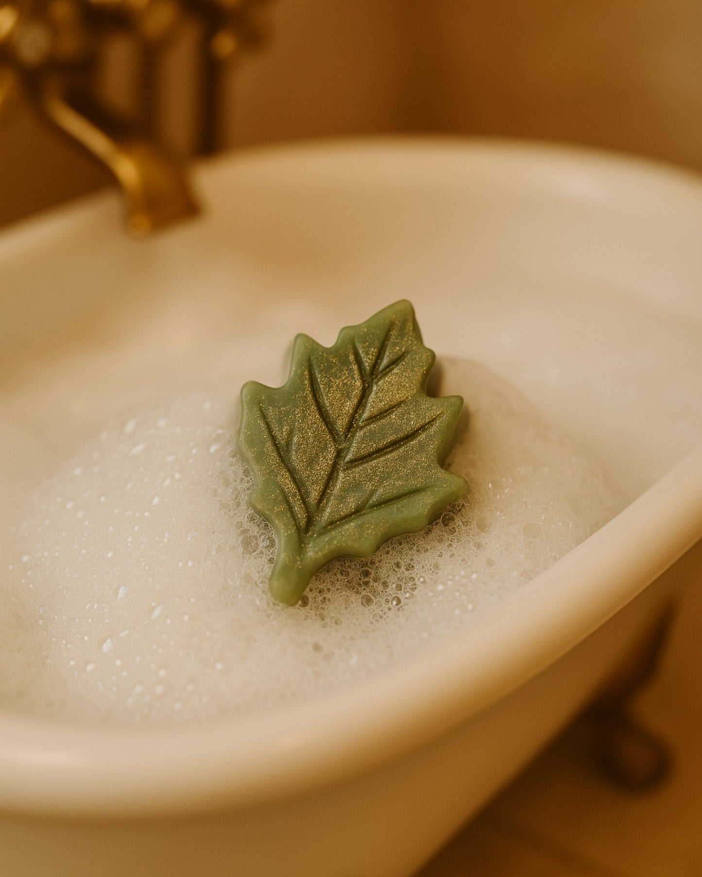 Elysian Leaf luxury soap resting in a marble bathtub with natural foam — pure botanical cleansing inspired by ancient Greek beauty, combining pine, orange, and green clay for a divine bathing moment