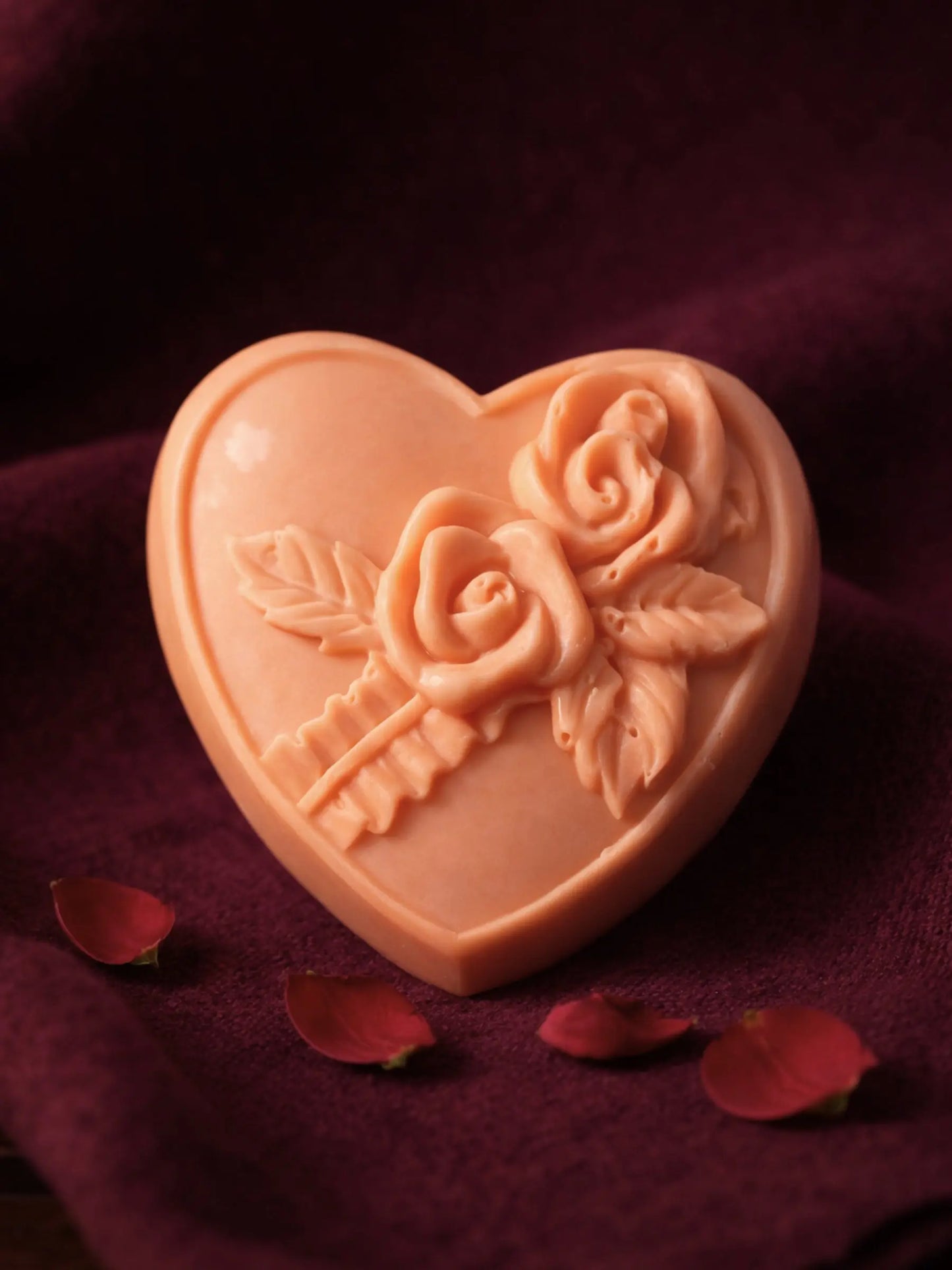 ROSEA heart-shaped soap with floral rose design displayed on velvet material with rose petals, luxury Valentine’s gift soap by Deos Co with rose geranium and vanilla