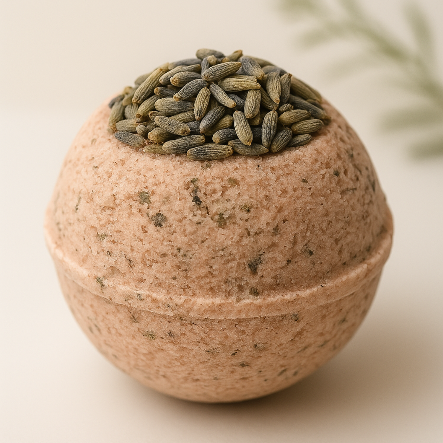 A handcrafted lavender bath bomb made with natural ingredients, topped with dried lavender buds, displayed against a minimal beige background with a soft green botanical accent by DEOS Co.
