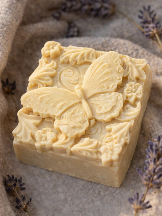 The Metamorphé butterfly relief soap by DEOS Co., Nardus Bliss Collection—handcrafted with organic Greek olive oil and pure lavender essential oil, styled with dried lavender on textured stone.