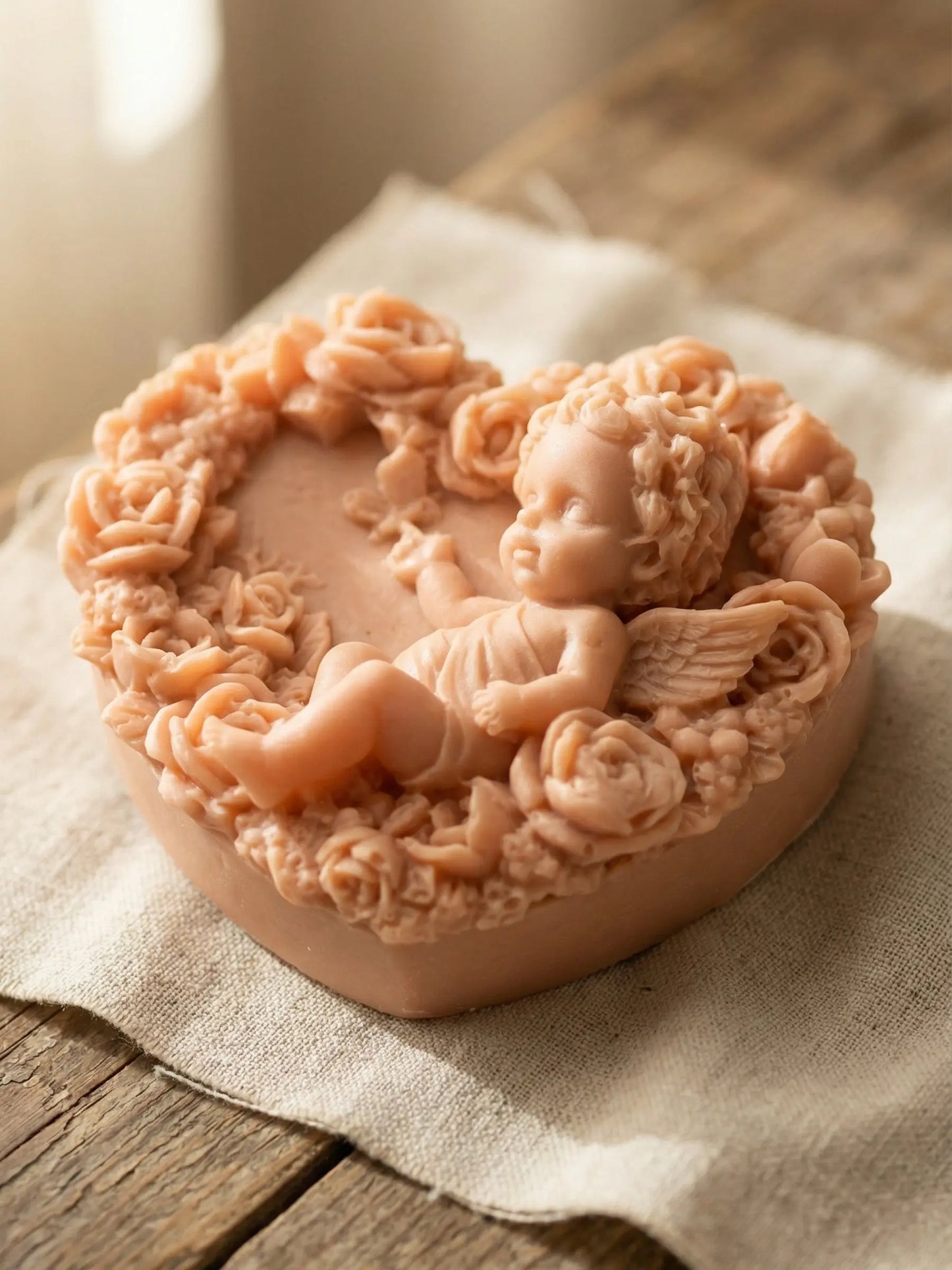 Heart-shaped Eros Angel soap resting on linen fabric, natural Rose Geranium & Vanilla soap from the Valentine’s Day Collection by DEOS CO