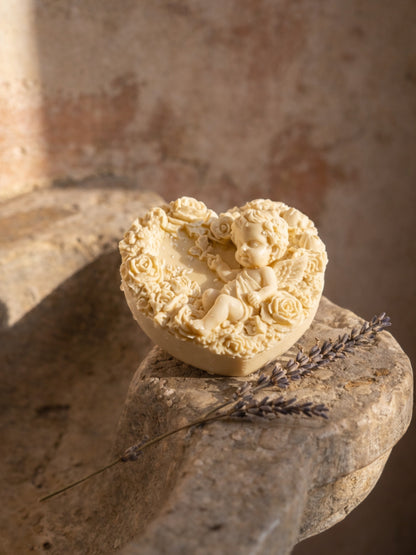 Decorative heart-shaped natural organic soap with floral and angel figure design on a stone surface with lavender flowers by DEOS CO

The Eros Angel — Pure Olive Oil & Lavender Soap | Nardus Bliss Collection