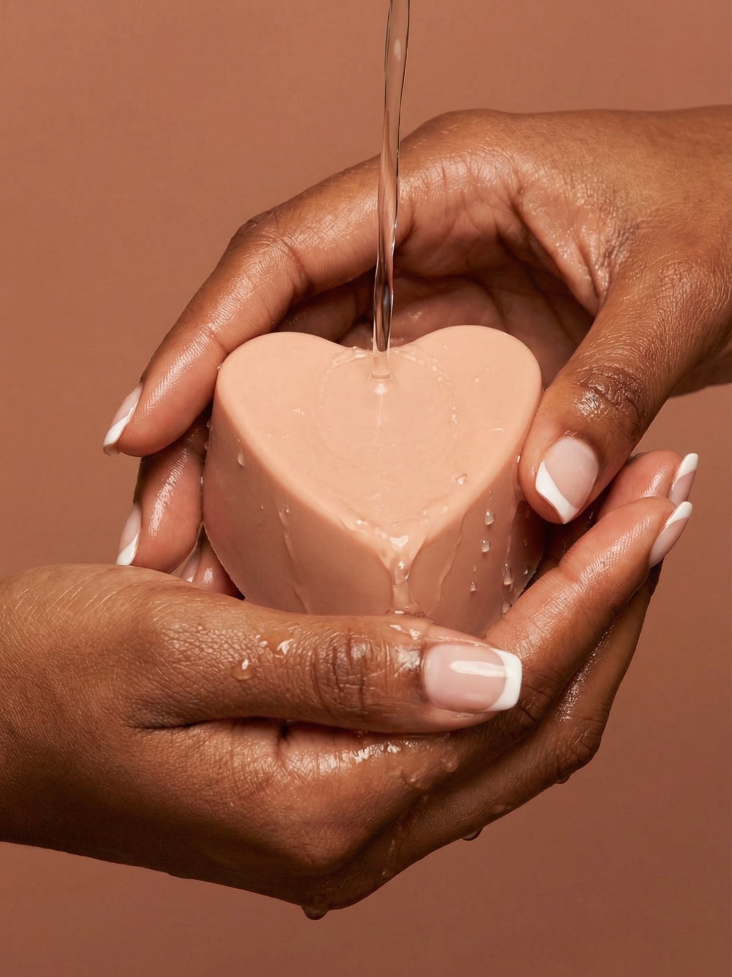 Handcrafted AGĀPE heart soap by DEOS Co. held in hands, rose geranium and vanilla natural soap inspired by pure love Valentine's Day