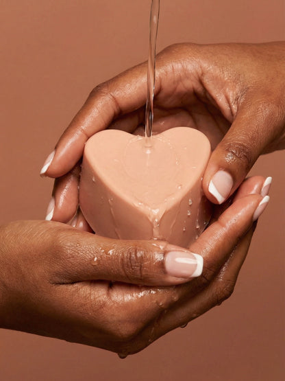 Handcrafted AGĀPE heart soap by DEOS Co. held in hands, rose geranium and vanilla natural soap inspired by pure love Valentine's Day