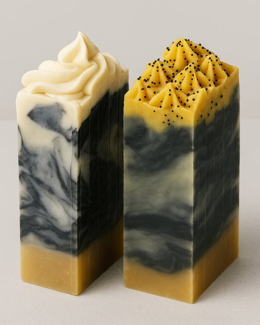 Handcrafted activated charcoal soap bar with yellow vanilla top and exfoliating poppy seeds displayed on a neutral background. Aetheria Glow by DEOS Co.
