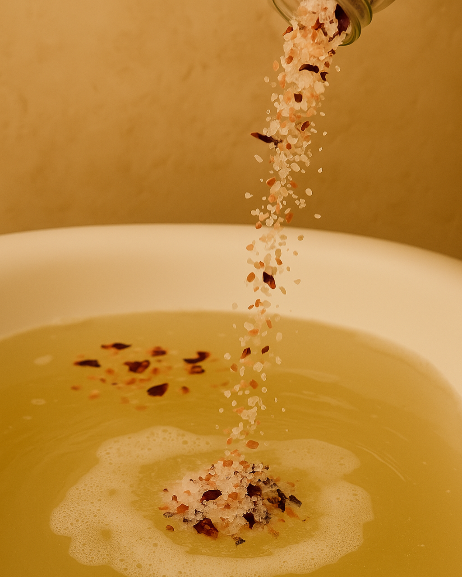 Luxurious Aphrodite’s Bloom Rose Bath Soak by DEOS Co. dissolving in a warm bath — a moment of relaxation and indulgent Greek-inspired wellness. Bath Salts