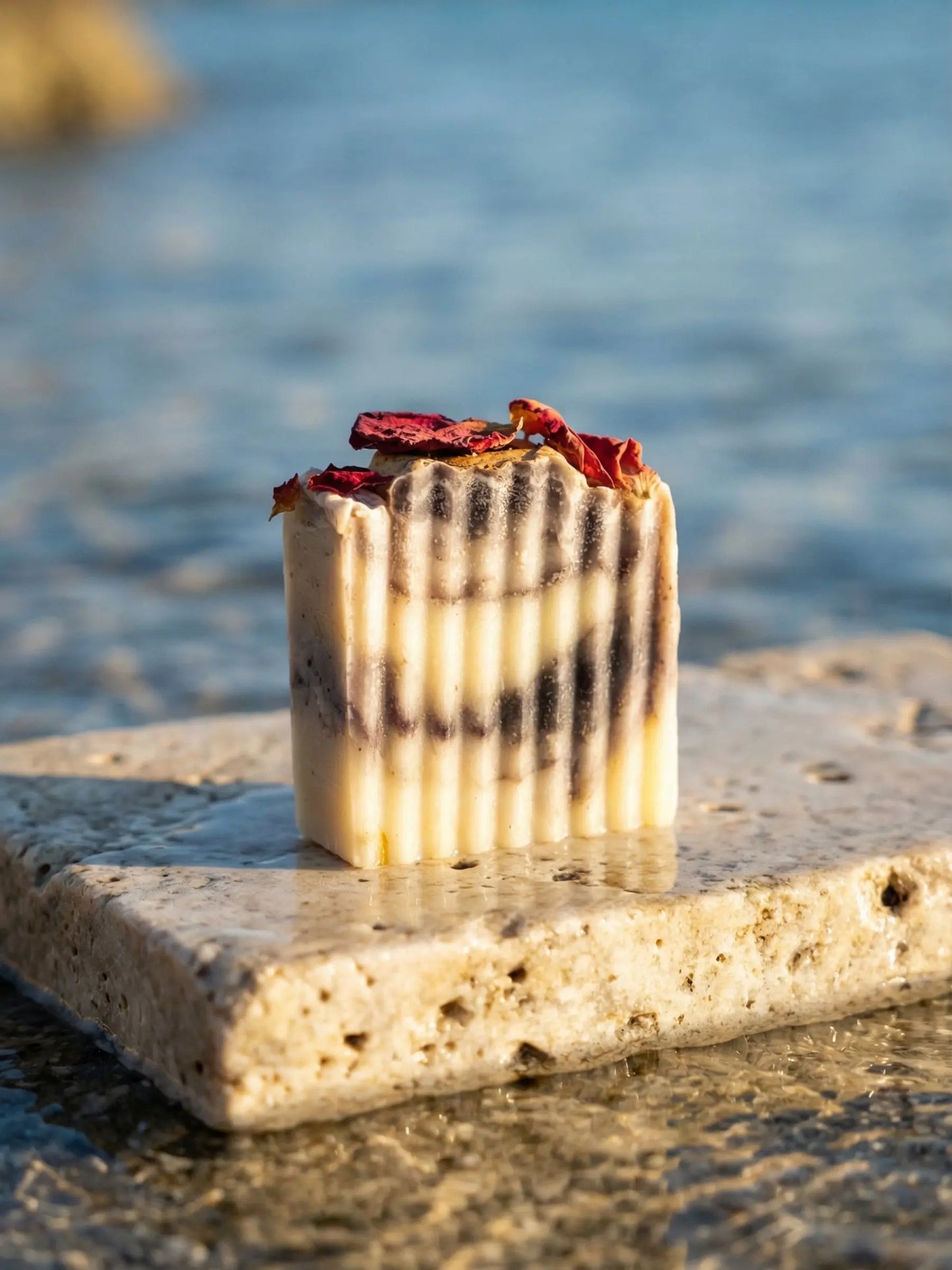 Hellenic Harmony handmade olive oil soap by DEOS Co resting on limestone slab in Mediterranean sunlight natural skincare product