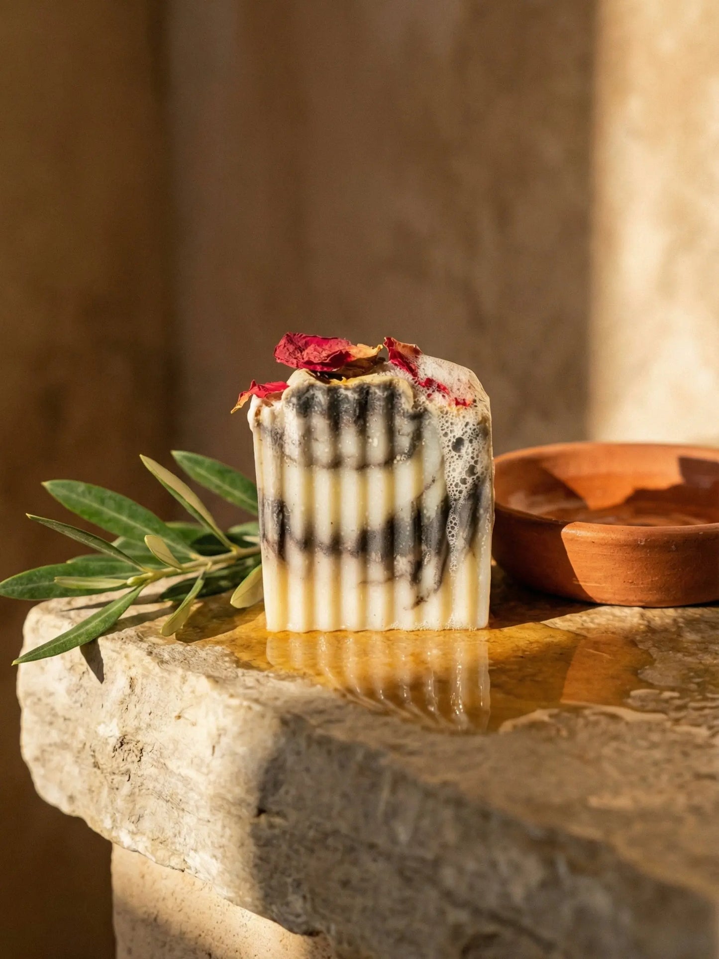 Hellenic Harmony olive oil soap with olive leaves and terracotta dish showcasing natural Greek inspired skincare by DEOS Co