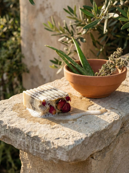 Hellenic Harmony natural olive oil soap placed on rustic stone pedestal in Mediterranean setting luxury handmade soap by DEOS Co