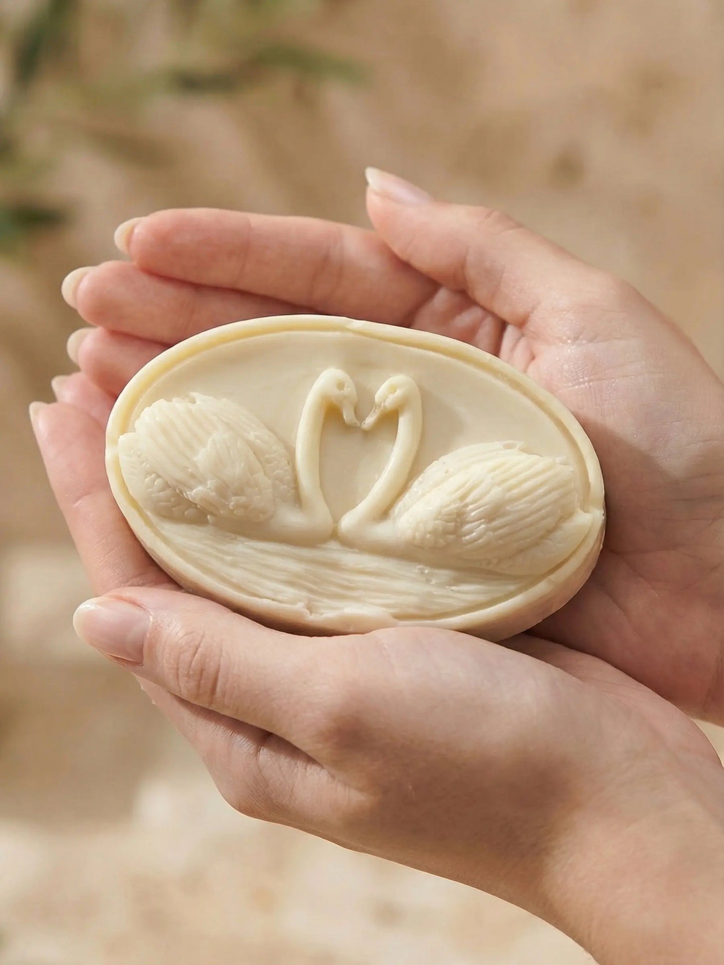 Hand holding KYKNOS swan soap crafted with pure Greek olive oil and lavender, artisan sculpted soap by DEOS Co.