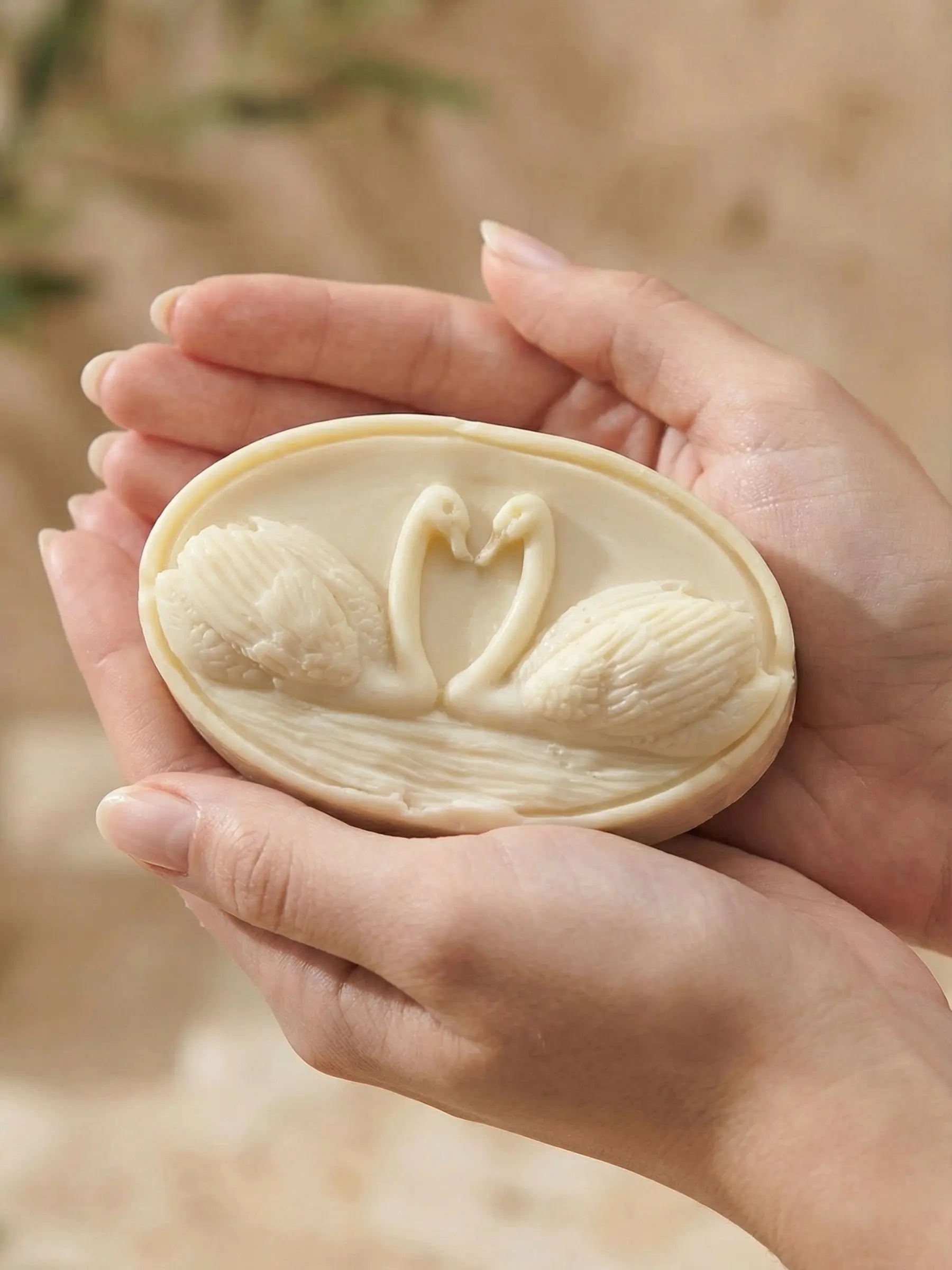 Hand holding KYKNOS swan soap crafted with pure Greek olive oil and lavender, artisan sculpted soap by DEOS Co.