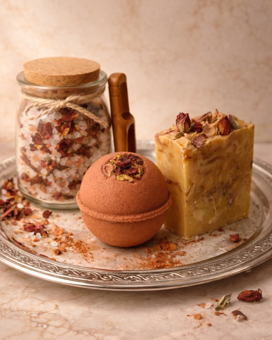 Luxury rose bath gift set with Aphrodite’s Glow soap, Aphrodite’s Sphere bath bomb, and Aphrodite’s Bloom mineral bath soak arranged on a silver tray