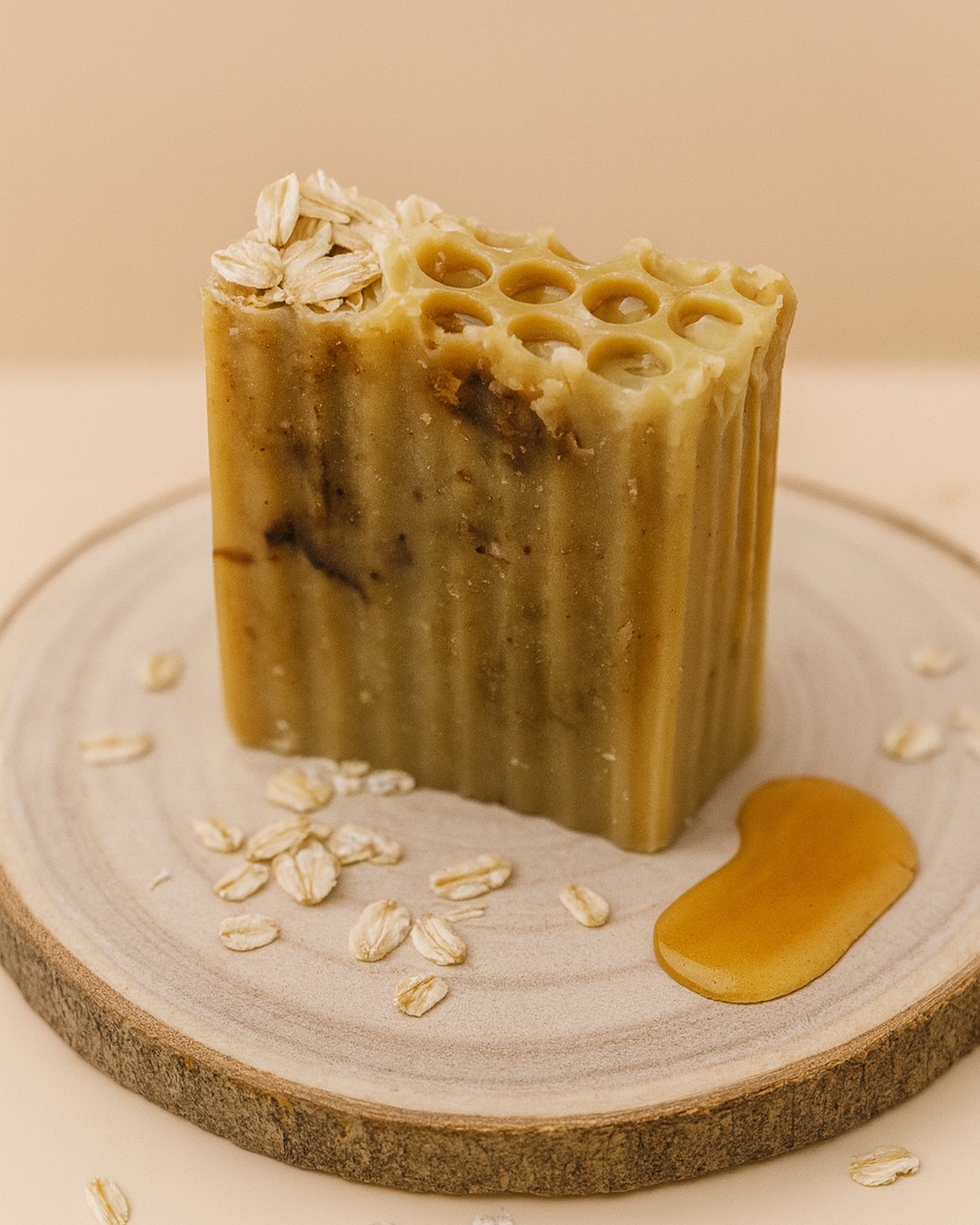 Bar of Melia Therion soap with honeycomb texture and oats on a wooden surface