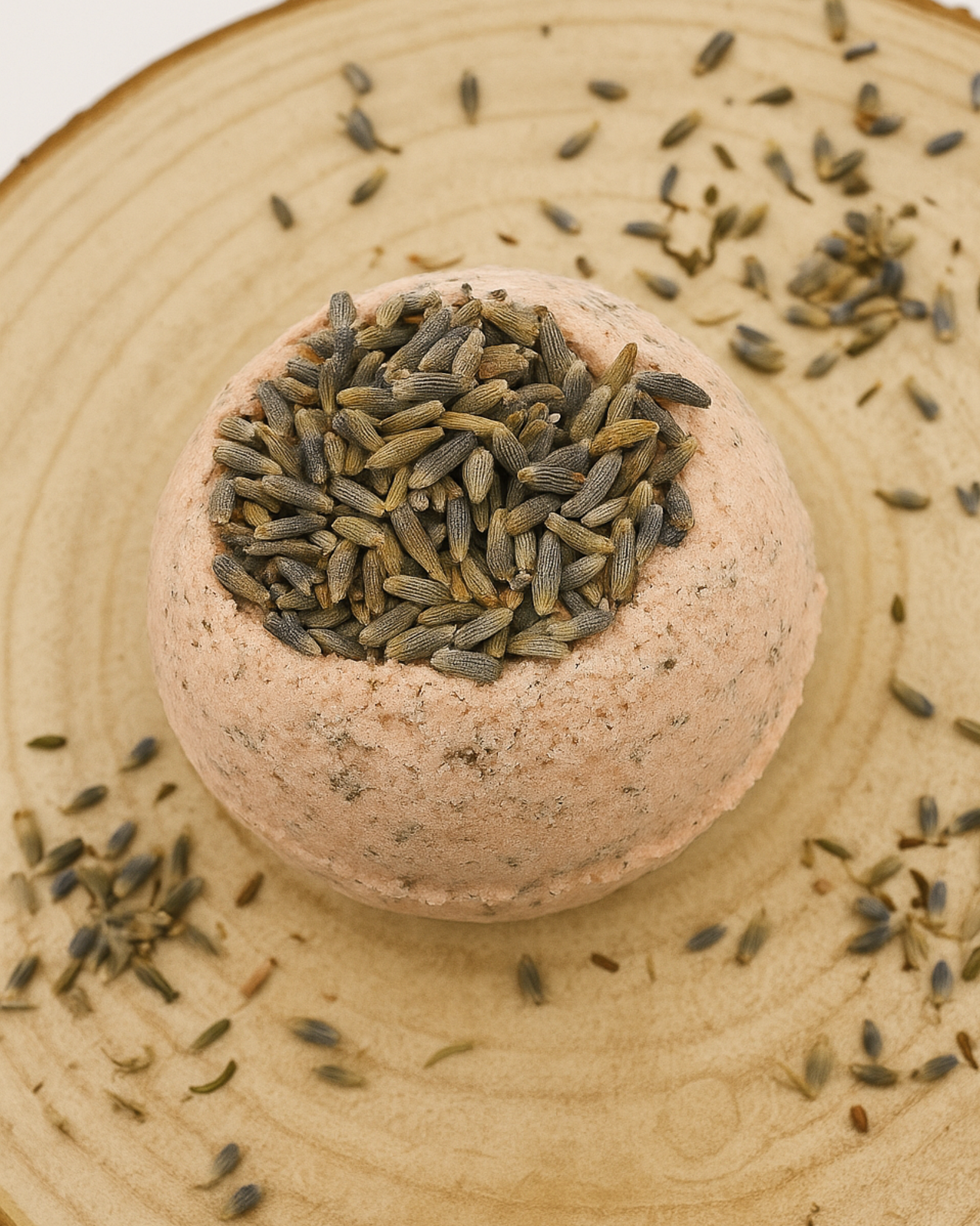 Nardus Sphere bath bomb with dried herbs on a wooden surface by DEOS CO.
