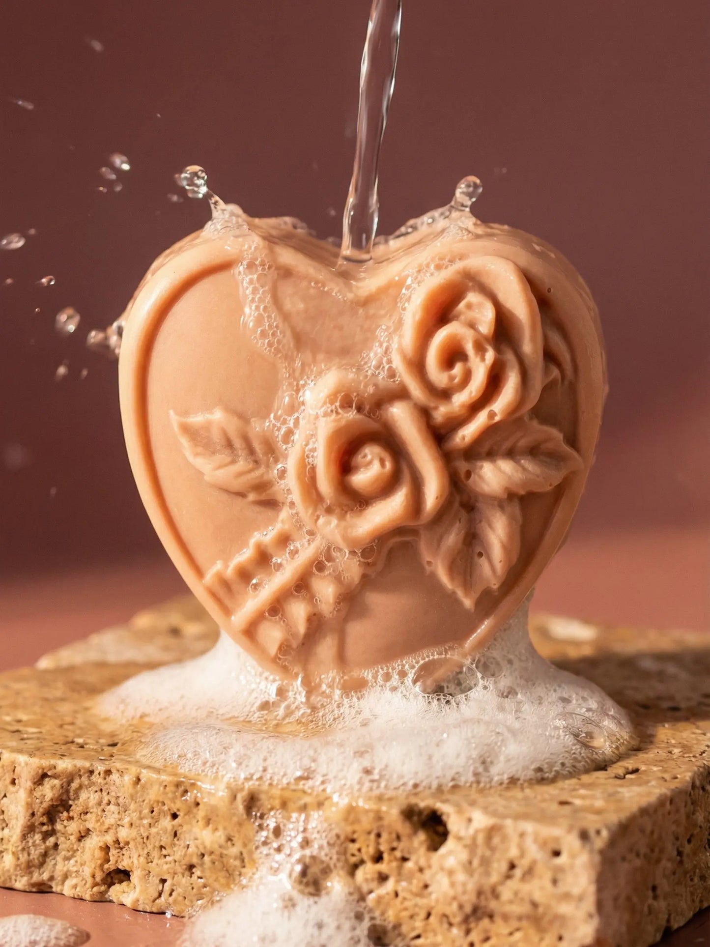 Rosea heart soap with carved rose detail under flowing water, handmade natural olive oil soap for Valentine’s Day by DEOS CO. with rose geranium and vanilla