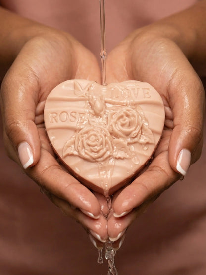 Hands holding Rosélia heart-shaped rose soap with botanical engraving, natural rose geranium and vanilla cleansing bar from Deos Co.