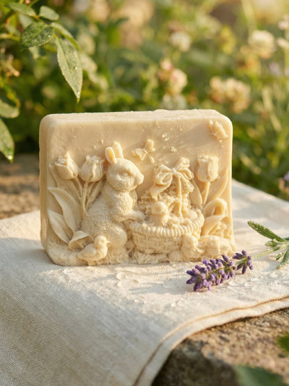 DEOS Co. THALÉA olive oil and lavender bunny soap from the Nardus Bliss Collection displayed outdoors on linen with lavender sprigs in soft natural sunlight
