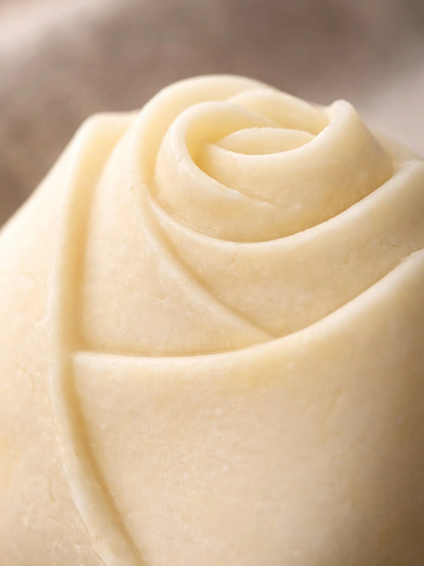 Close-up detail of handcrafted olive oil lavender soap with smooth sculpted finish / DEOS Co. The Bud Soap
